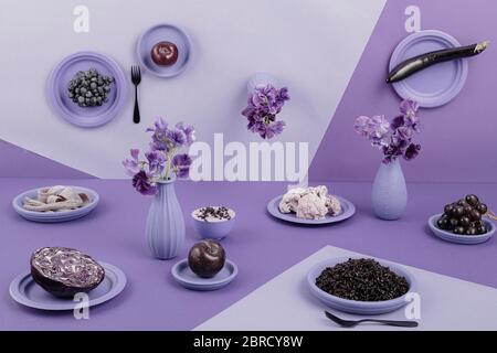 Tavolo in viola, prospettiva, surreale, melanzane, cavolo rosso, riso, yogurt, uva, mela, fiori, cavolfiore, natura morta, fotografia alimentare Foto Stock