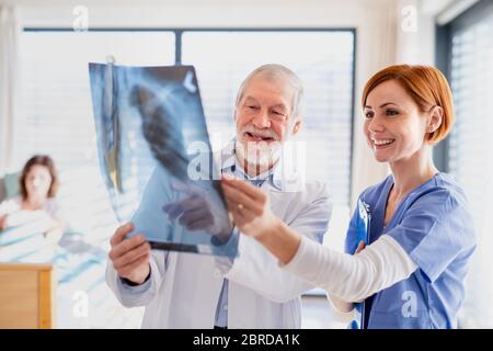Medici in piedi in camera d'ospedale, esaminando un radiografia. Foto Stock