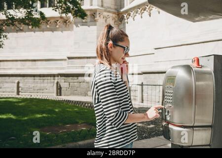 Ragazza turistica che parla o chiama su un telefono di strada in una strada in Italia. Turismo e comunicazione. Foto Stock