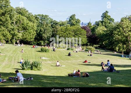 Londra Maggio 19 2020 persone che mantengono la distanza fisica per prendere il sole a Waterlow Park durante il blocco pandemico del coronavirus, Londra del Nord, Regno Unito Foto Stock