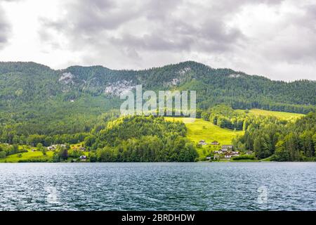 Lago di montagna vicino alle alpi Euopee con verde foresta e campo, giorno nuvoloso Foto Stock