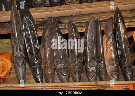 Tradizionali facce in legno, souvenir in esposizione nella foresta tropicale, Isola di Nosy Komba, Madagascar. Foto Stock