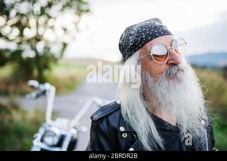 Uomo anziano con moto e occhiali da sole in campagna Foto stock - Alamy