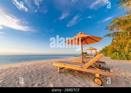 Bellissima spiaggia al tramonto. Sedie sulla spiaggia di sabbia vicino al mare. Vacanza estiva e concetto di vacanza per il turismo. Esotico paesaggio tropicale destinazione Foto Stock