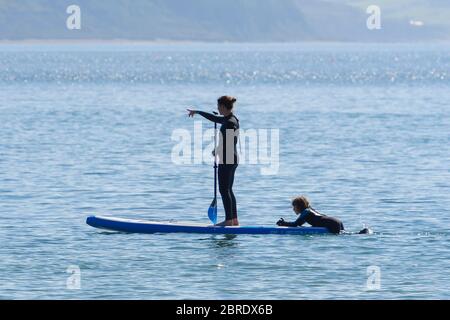 Lyme Regis, Dorset, Regno Unito. 21 maggio 2020. Regno Unito Meteo. Un paddle boarder sull'acqua presso la località balneare di Lyme Regis in Dorset in una mattina calda bruciante. Immagine: Graham Hunt/Alamy Live News Foto Stock