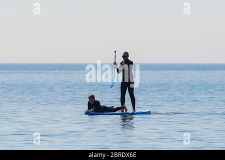 Lyme Regis, Dorset, Regno Unito. 21 maggio 2020. Regno Unito Meteo. Un paddle boarder sull'acqua presso la località balneare di Lyme Regis in Dorset in una mattina calda bruciante. Immagine: Graham Hunt/Alamy Live News Foto Stock