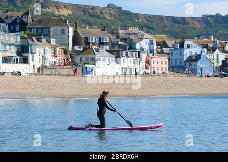 Lyme Regis, Dorset, Regno Unito. 21 maggio 2020. Regno Unito Meteo. Un paddle boarder sull'acqua presso la località balneare di Lyme Regis in Dorset in una mattina calda bruciante. Immagine: Graham Hunt/Alamy Live News Foto Stock