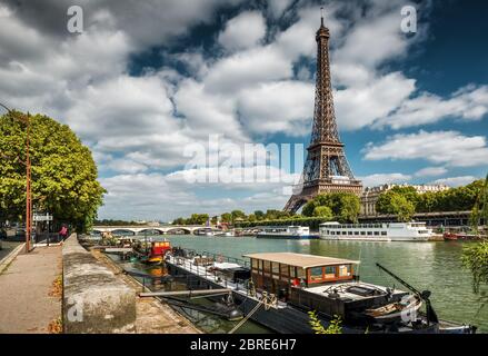 La Senna con le barche e la Torre Eiffel a Parigi. Chiatte residenziali in primo piano. Foto Stock