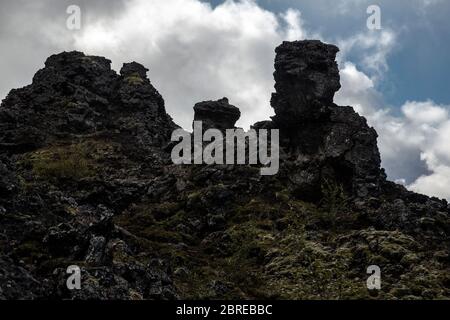 Vista di Dimmuborgir, una formazione vulcanica situata nella regione del lago Mývatn. Le formazioni laviche raffreddate sono nere, con qualche vegetazione nelle vicinanze Foto Stock