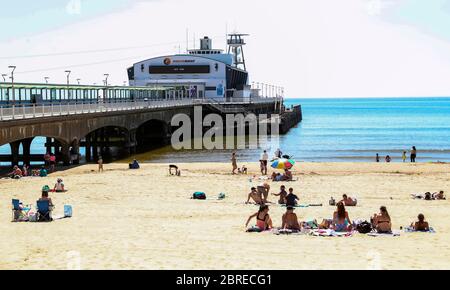 La gente gode il tempo caldo a Bournemouth, Dorset, come la gente si accorrono ai parchi e alle spiagge con le misure di blocco attenuate. Foto Stock