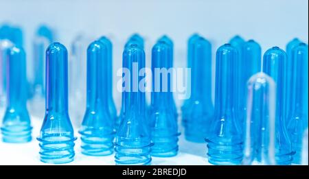 Preforme di bottiglie di PET prima di stampaggio per soffiatura, il riempimento e la procedura di etichettatura. PET blu della preforma di bottiglia per industria delle bevande. Il materiale grezzo per la bottiglia di PET con Foto Stock