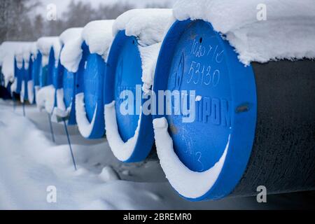 Barnaul, Russia-13.12.2018: Tubi per la gassificazione con l'iscrizione Gazprom si trovano in un magazzino aperto in inverno. Foto Stock