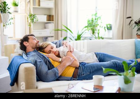 Felice coppia innamorata sul divano interno a casa, dormire. Foto Stock