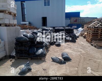 Pacchetti con macerie e sabbia sul cantiere. Base dei materiali da costruzione. Foto Stock