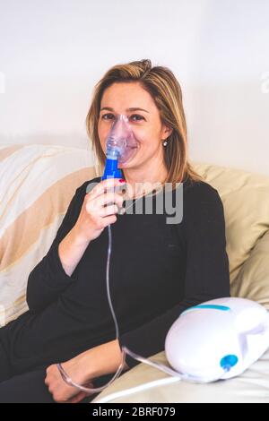 donna felice con nebulizzatore aerosol inalatore macchina verticale sfondo con copyspace Foto Stock