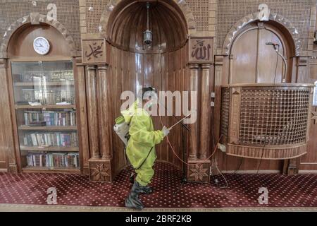 Gaza, territori palestinesi. 21 Maggio 2020. Un operaio del comune di Gaza con tuta protettiva spruzzi disinfettanti all'interno di una moschea come precauzione contro la pandemia del coronavirus. Credit: Mohammed Talatene/dpa/Alamy Live News Foto Stock