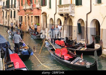 Venezia, Italia - 18 maggio 2017: I gondolieri con gondole si aspettano turisti a Venezia. La gondola è il mezzo di trasporto turistico più attraente di Venezia. Romantico Foto Stock