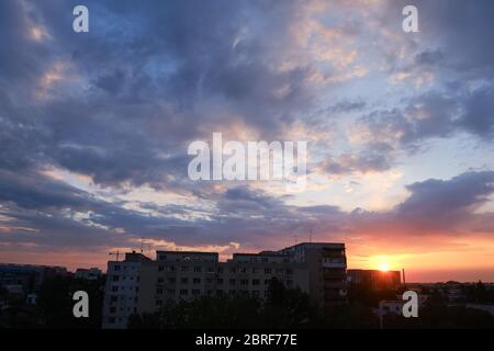 Alba urbana con nuvole viola e arancio nel cielo, dopo una tempesta, a Bucarest, Romania. Foto Stock