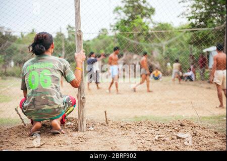 Un giovane cambogiano guarda il gioco di pallavolo in un villaggio. Battambang, Cambogia, Sud-est asiatico Foto Stock