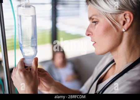 Un infermiere che prepara il fleboclisi in ospedale o a casa. Foto Stock