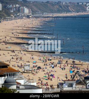 La gente gode il tempo caldo a Bournemouth, Dorset, come la gente si accorrono ai parchi e alle spiagge con le misure di blocco attenuate. Foto Stock