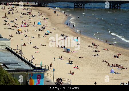 La gente gode il tempo caldo a Bournemouth, Dorset, come la gente si accorrono ai parchi e alle spiagge con le misure di blocco attenuate. Foto Stock