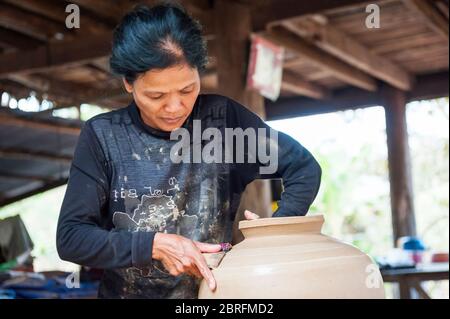 Una donna che forma una pentola di argilla usando un pipistrello di legno. Provincia di Kampong Chhnang, Cambogia, Sud-est asiatico Foto Stock