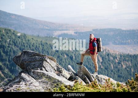 Uomo maturo con zaino escursioni in montagna in estate. Foto Stock