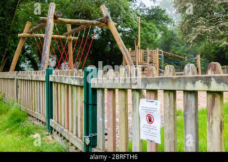 Un avviso del consiglio allegato ad una recinzione intorno ad un parco giochi che proibisce l'uso del parco giochi a causa delle norme di salute e sicurezza del Covid 19. Foto Stock