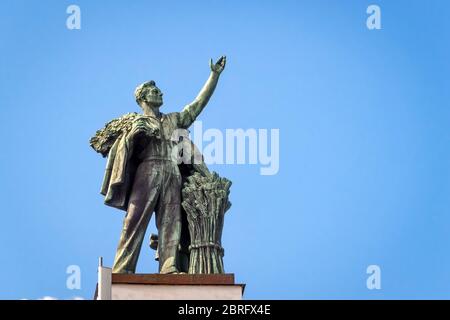 Architettura sovietica antica nel parco VDNKh (Mostra dei risultati dell'economia nazionale), Mosca, Russia. Statua sul padiglione principale al cielo blu ba Foto Stock