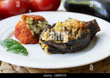 Il tradizionale dolma azerbaigiano delle melanzane ha anche chiamato tre sorelle fatte vegane: Un'melanzana e un pomodoro farcito con riso piccante e basilico Foto Stock