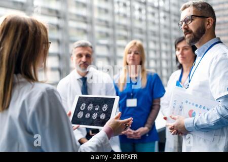 Gruppo di medici con tablet in conferenza medica, discutere di questioni. Foto Stock