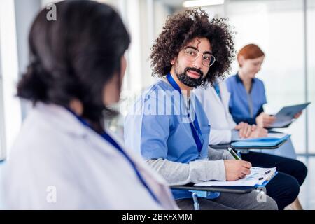 Gruppo di medici con tablet in conferenza medica, parlare. Foto Stock