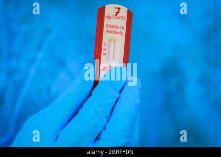 Baghdad, Iraq. 21 Maggio 2020. Un operatore sanitario del Ministero della Salute tiene un dispositivo di analisi del sangue durante un esame sul campo per eseguire il coronavirus (COVID-19) test per i cittadini nel quartiere sobborgo Sadr City a Baghdad. Credit: Ameer al Mohammedaw/dpa/Alamy Live News Foto Stock