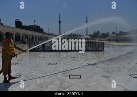 Lahore, Pakistan. 21 Maggio 2020. Il personale della società metropolitana pakistana Lahore (MCL) è occupato in spray anti-virus presso il santuario di Data Ali Hajveri noto come Data Ganj Buksh dopo che il governo ha rilassato il blocco di settimane che è stato imposto per aiutare a frenare la diffusione del coronavirus nella capitale provinciale Lahore. (Foto di Rana Sajid Hussain/Pacific Press) Credit: Pacific Press Agency/Alamy Live News Foto Stock