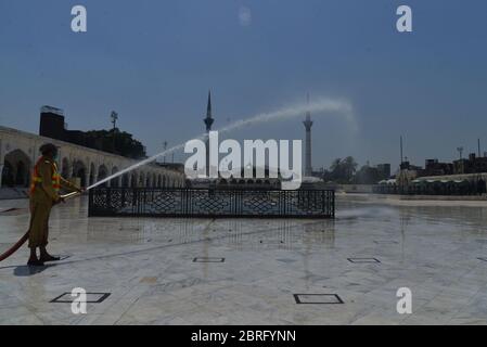 Lahore, Pakistan. 21 Maggio 2020. Il personale della società metropolitana pakistana Lahore (MCL) è occupato in spray anti-virus presso il santuario di Data Ali Hajveri noto come Data Ganj Buksh dopo che il governo ha rilassato il blocco di settimane che è stato imposto per aiutare a frenare la diffusione del coronavirus nella capitale provinciale Lahore. (Foto di Rana Sajid Hussain/Pacific Press) Credit: Pacific Press Agency/Alamy Live News Foto Stock