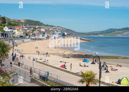 Lyme Regis, Dorset, Regno Unito. 21 Maggio 2020. Regno Unito Meteo: Locali e famiglie godono del caldo sole del pomeriggio presso la località balneare di Lyme Regis. Nonostante i parcheggi restassero chiusi, la spiaggia era più trafficato questo pomeriggio con i beachgoers responsabili che mantenevano le distanze sociali mentre si prendeva il sole. Credit: Celia McMahon/Alamy Live News Foto Stock