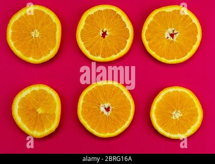 set di arance tritate su sfondo rosa Foto Stock