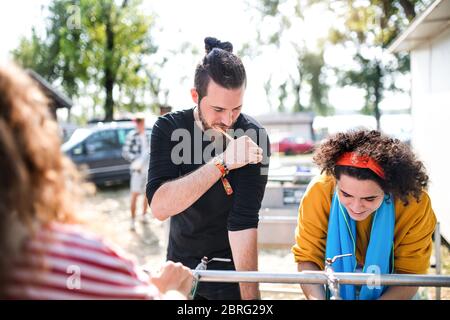 Gruppo di giovani amici al festival estivo, lavaggio al mattino. Foto Stock