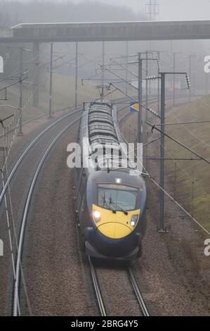 Treno passeggeri ad alta velocità classe 395 nella livrea sud-orientale che accelera lungo la pista in una giornata di nebbia in Inghilterra. Foto Stock