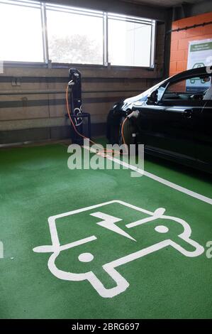 Utilizzando un punto di ricarica per auto elettriche presso un parcheggio della stazione ferroviaria, per caricare un'auto Vauxhall Ampera. Foto Stock