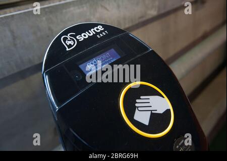 Utilizzando un punto di ricarica per auto elettriche presso un parcheggio della stazione ferroviaria, per caricare un'auto Vauxhall Ampera. Foto Stock