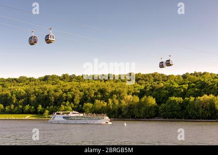 La barca turistica galleggia lungo il fiume Moskva, Mosca, Russia. Vista panoramica della funivia tra le colline del Passero e lo stadio Luzhniki di Mosca. Cablewa Foto Stock