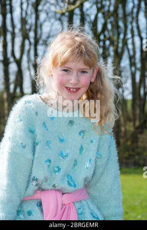 giovane ragazza sedette su recinzione in campagna sorridente, lancashire, inghilterra, regno unito Foto Stock