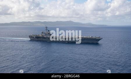 Apra Harbour, Stati Uniti. 21 Maggio 2020. La portaerei della marina statunitense di classe Nimitz USS Theodore Roosevelt parte da Guam e si dirige verso il mare il 21 maggio 2020 nel Mare delle Filippine. L'equipaggio negativo del COVID è tornato dalla quarantena e sta tornando in mare per continuare il loro dispiegamento programmato nell'Indo-Pacifico. Credito: Kaylianna Genier/USA Notizie dal vivo sulla Marina/Alamy Foto Stock