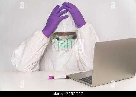 I medici in tute e e maschere di protezione stanno tenendo la testa, infelice e stanca causa di overwork, sottolineato esausto, il concetto di diffusione Coronavi Foto Stock