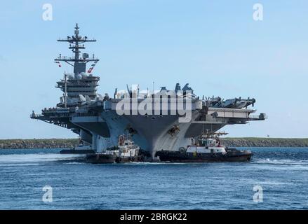 Apra Harbour, Stati Uniti. 21 Maggio 2020. La portaerei della marina statunitense di classe Nimitz USS Theodore Roosevelt viene trainata fuori dal molo quando parte dalla base navale Guam 21 maggio 2020 ad Apra Harbour, Guam. L'equipaggio negativo del COVID è tornato dalla quarantena e sta tornando in mare per continuare il loro dispiegamento programmato nell'Indo-Pacifico. Credit: Macadam Kane Weissman/USA Notizie dal vivo sulla Marina/Alamy Foto Stock