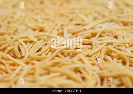 Pasta fatta in casa con farina integrale sana su un panno da cucina. Foto Stock