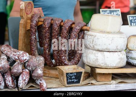 Saint-Palais-sur-Mer, Charente-Maritime / Francia: Varie salsicce francesi secche salate (saucisson) e ruote di formaggio disposti su un mercato. Foto Stock