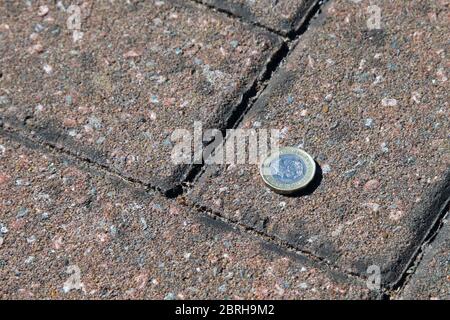2017 £1 moneta giacente sul pavimento, trovando i soldi sul pavimento Foto Stock